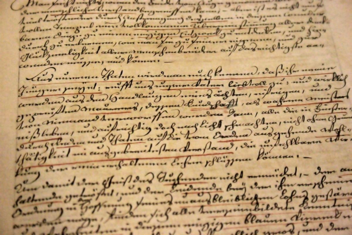 Tanned old document with cursive black and red writing.