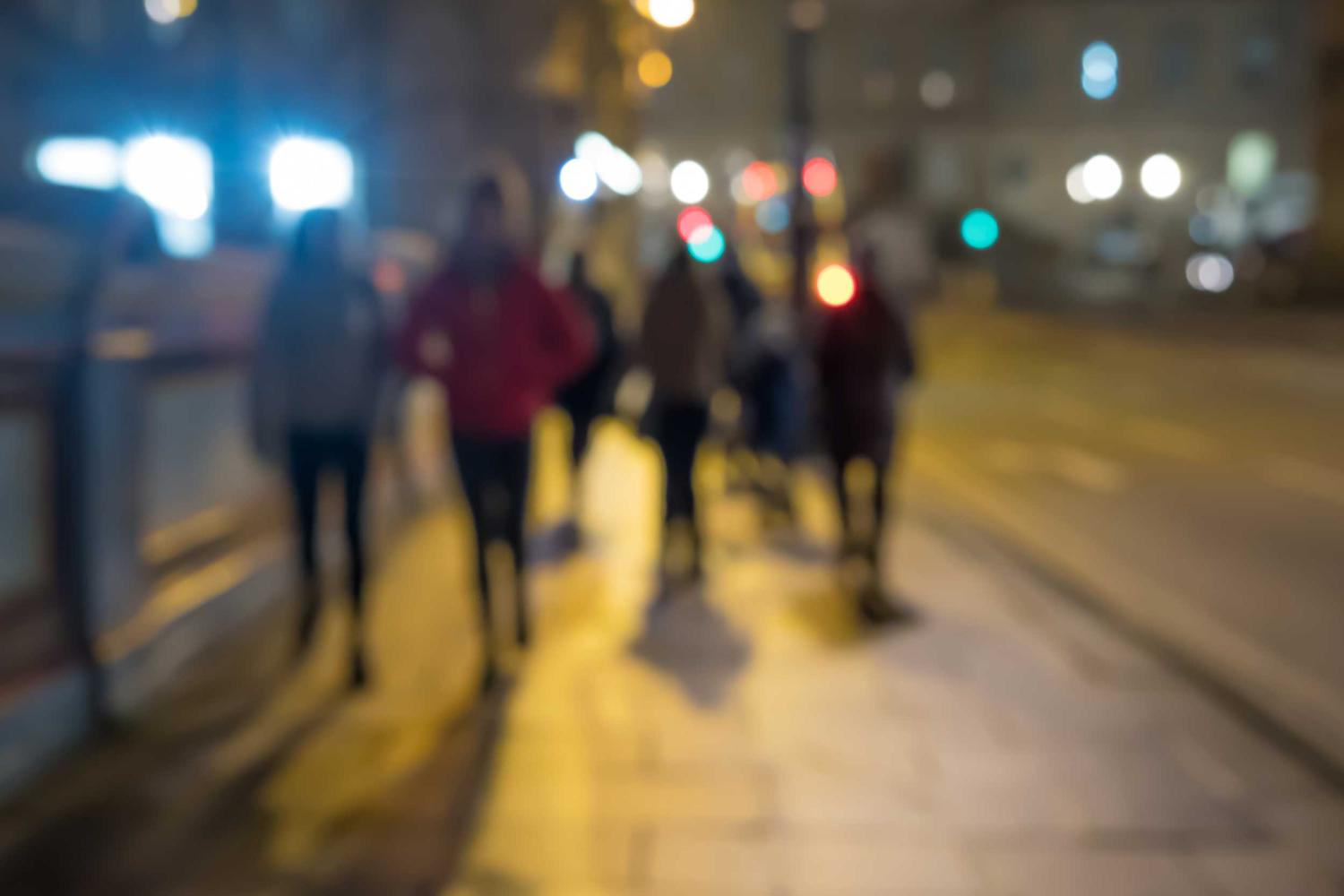 Group walking down the sidewalk at night