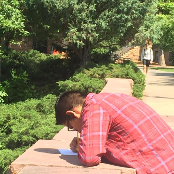 a student writing on a piece of paper