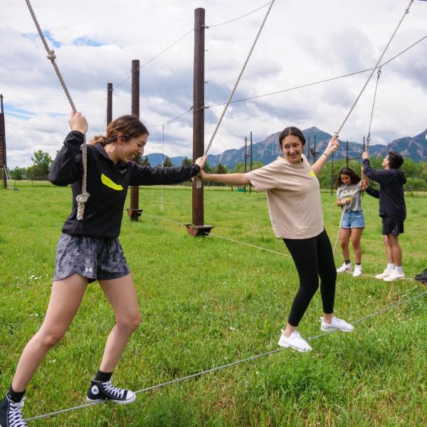 students working together on a ropes course