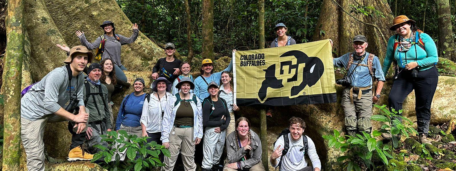 Group of CU students with CU flag in Vietnamese forest