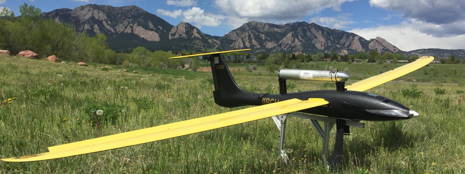 A UAV resting on the ground with the flatirons in the background.