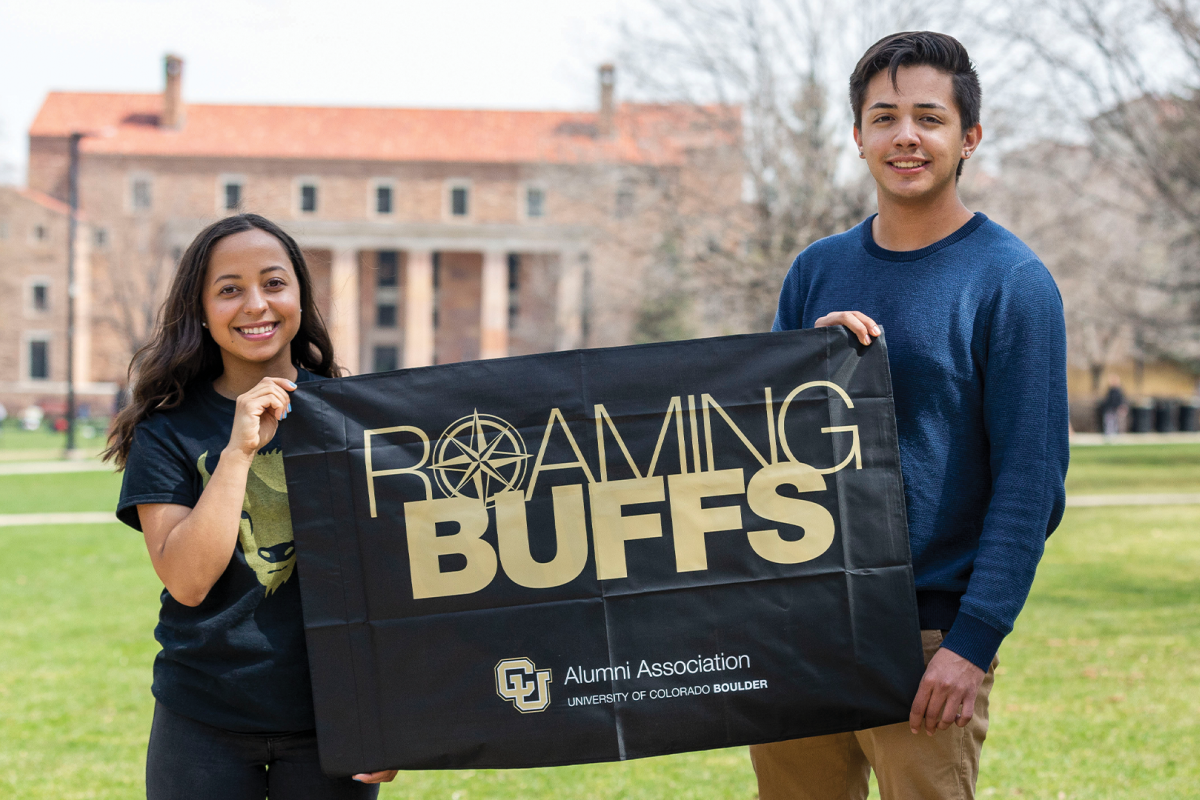 Alumni holding CU Boulder flag