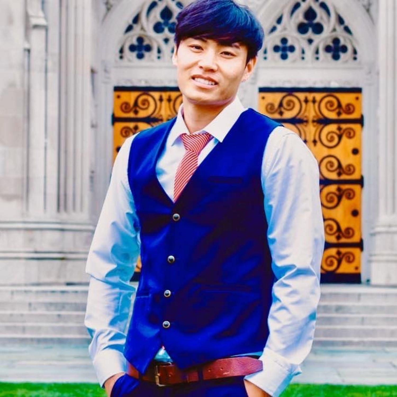 Sangjie Zhaxi standing in front of an ornate building door