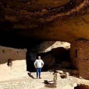 Carlton standing in a cliff dwelling