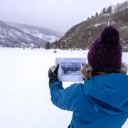 Carole McGranahan holds up an old photo of Dumra to find its precise location in Camp Hale National Monument.