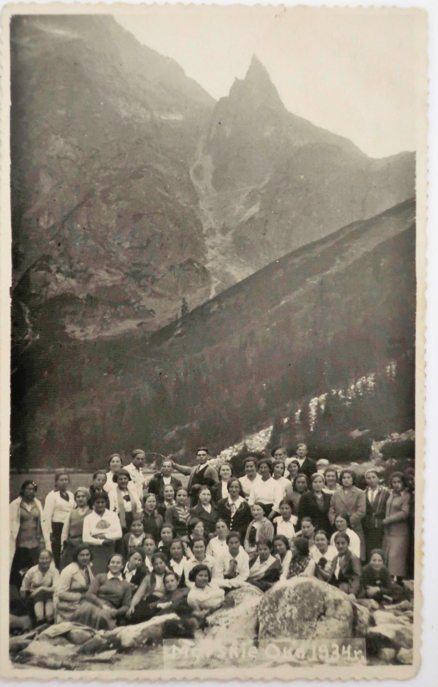 a group of people standing by mountains.