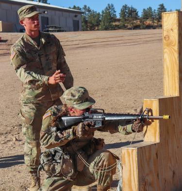 Cadet White instructs another Cadet on proper marksmanship techniques. Photo courtesy of Cadet Arianna Decker.