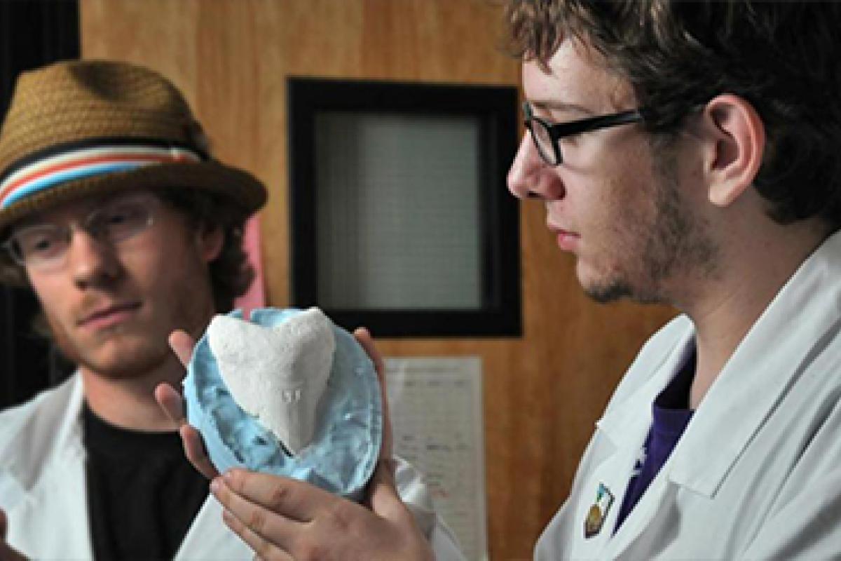 Two students examine a prehistoric stone