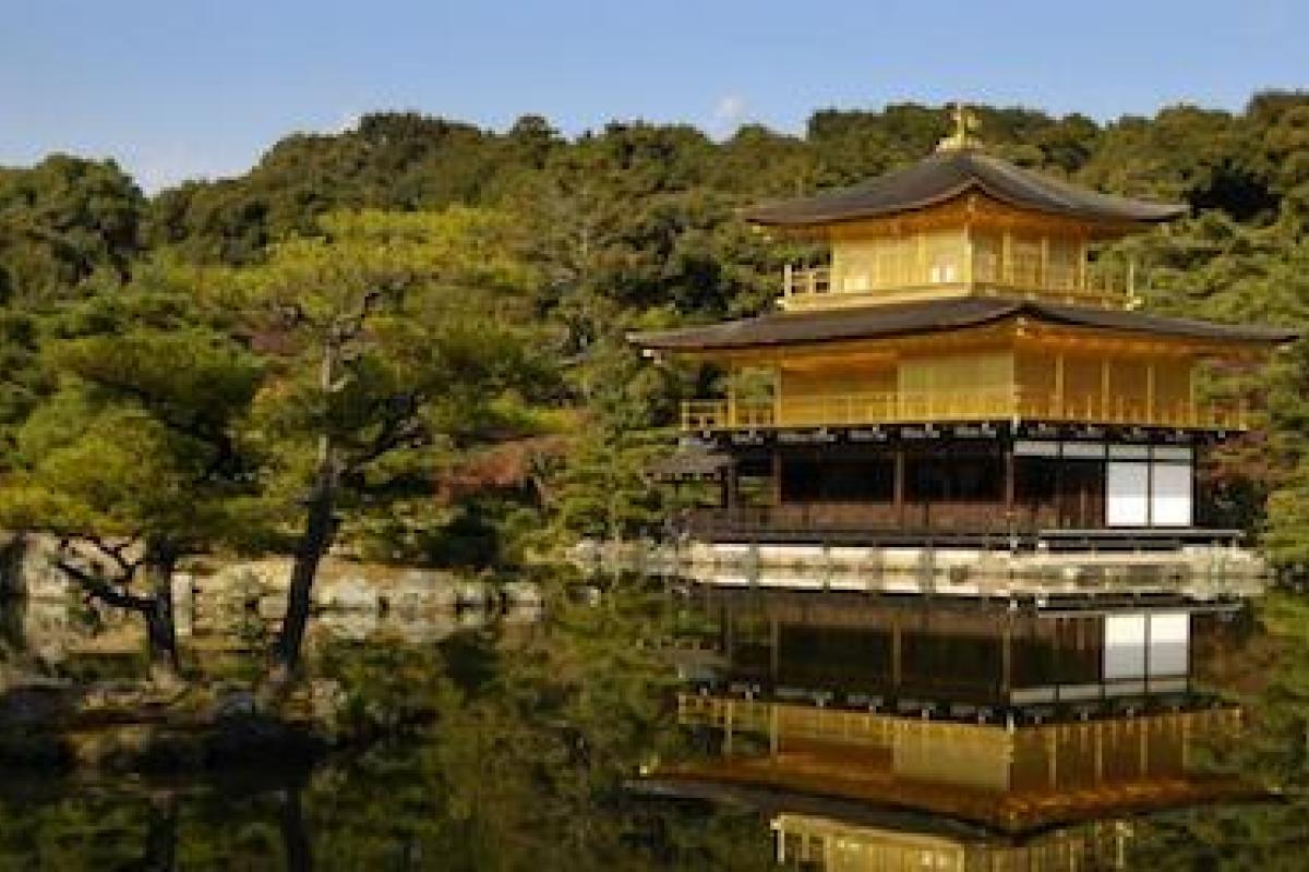 A temple in East Asia sits beside a peaceful pond.