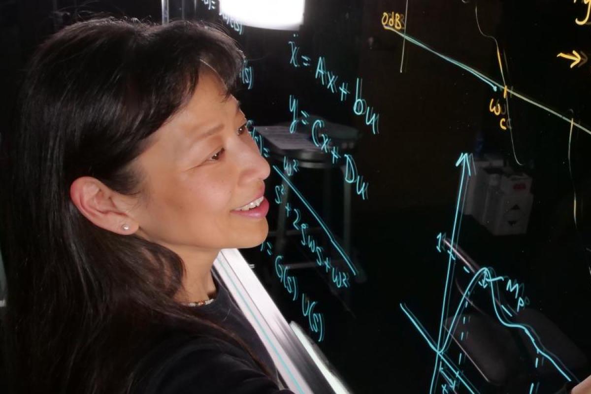 A faculty member draws a math equation on a virtual blackboard.