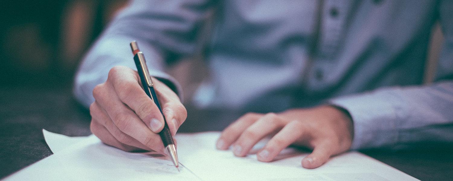 man writing on paper