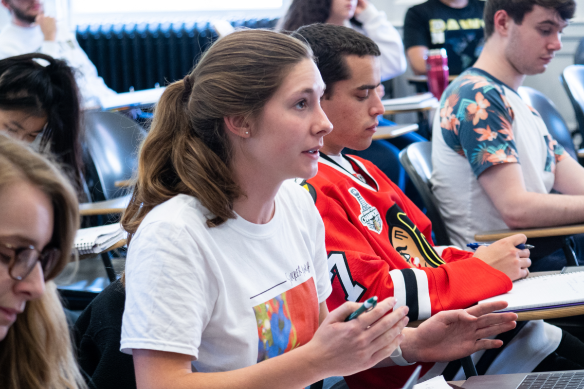 Students in a classics seminar ask a question to the faculty leading the class.