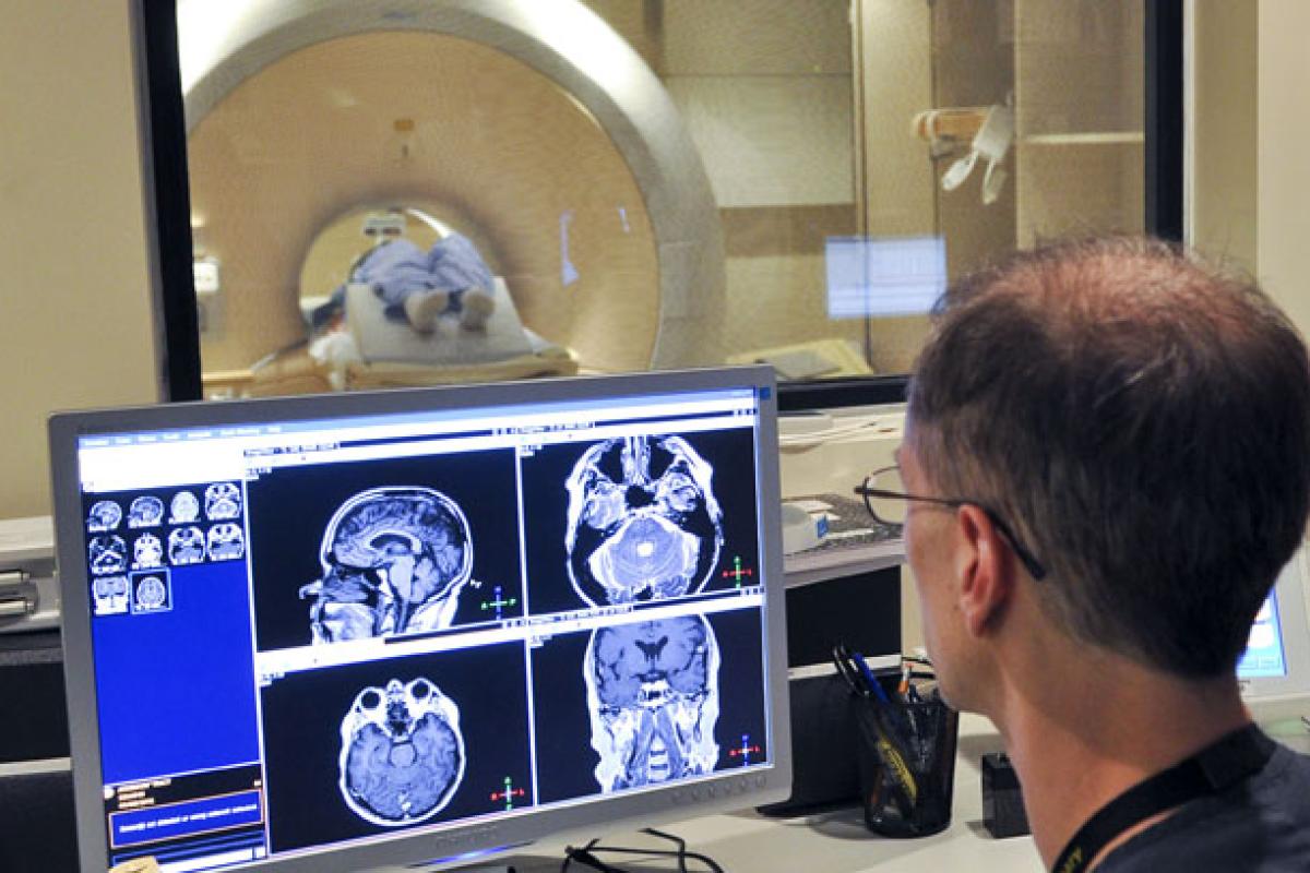 Two people look at a scan of a brain.