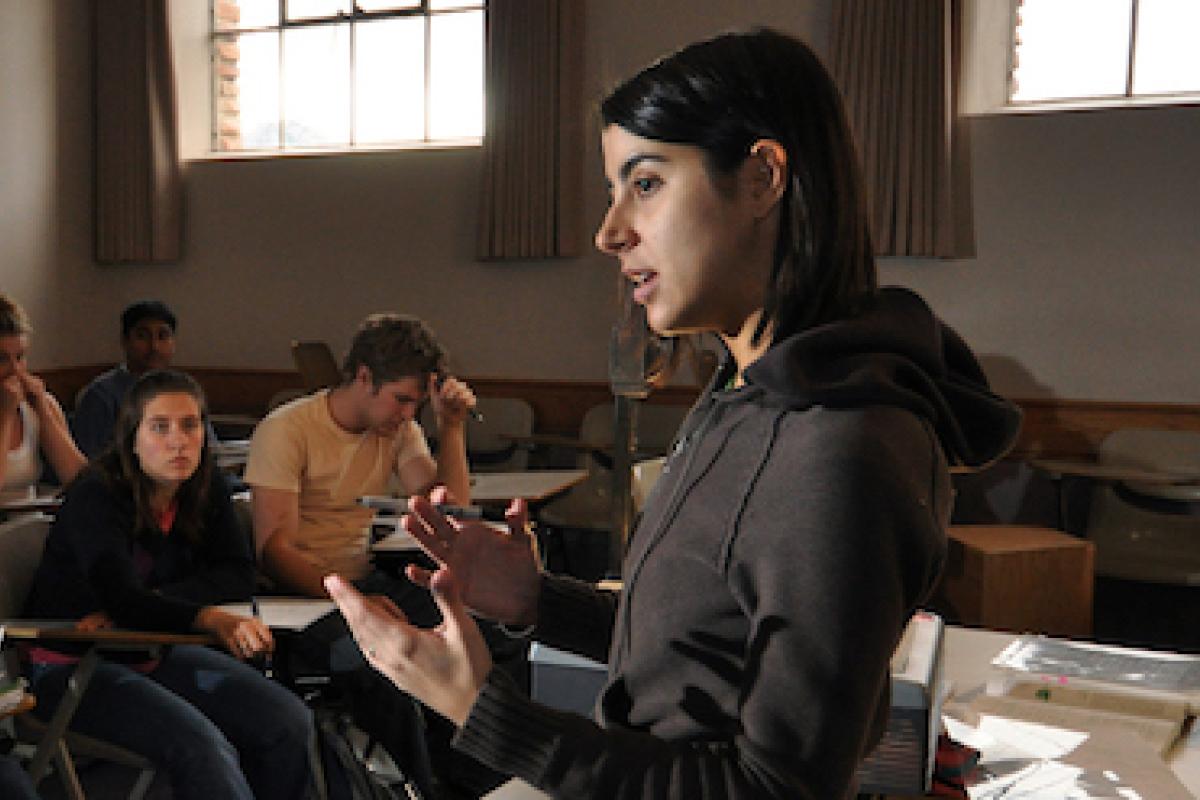 A faculty member delivers a lecture to a small seminar class.