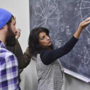 instructor at blackboard explaining algorithm