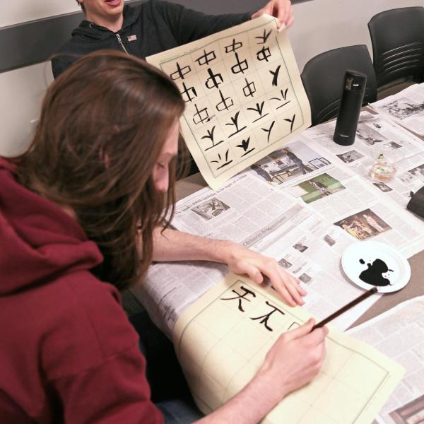 Students writing Chinese characters