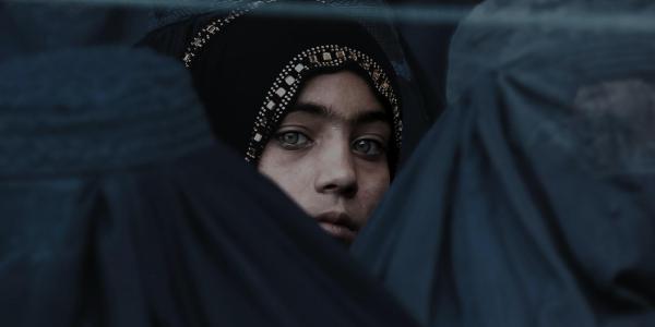 Afghani woman looking through a crowd