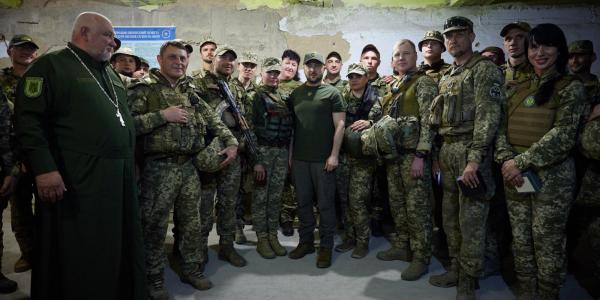 Ukrainian President Volodymyr Zelenskyy, center, stands with troops from his country in summer 2022.