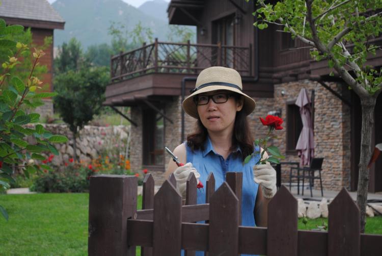 Annie Liu outside her home with a rose
