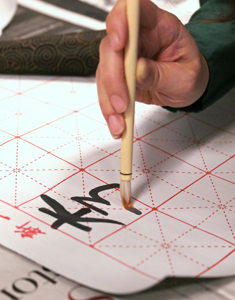 Hand holding calligraphy brush