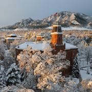 Old Main and Flatirons blanketed in snow at sunrise