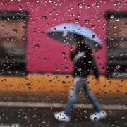 Person walking in rain with umbrella
