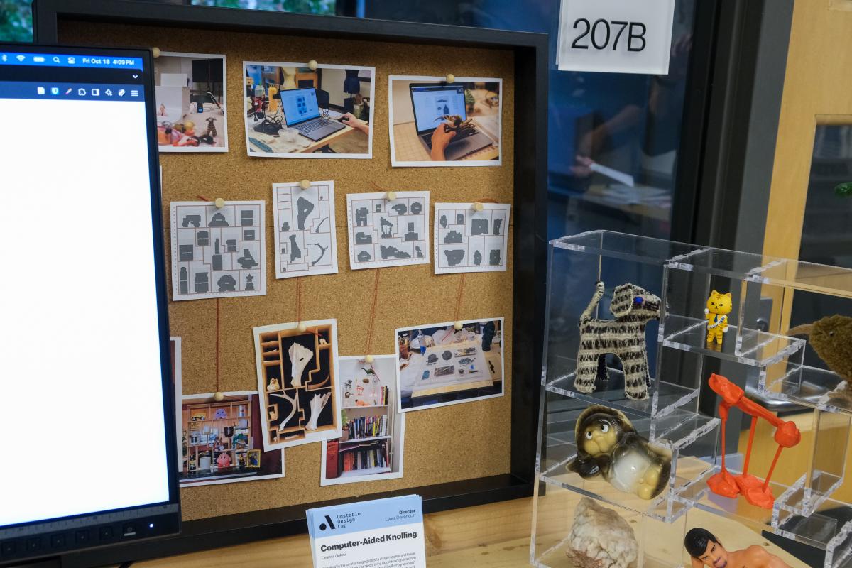 A corkboard displays various knolling pattern. A small clear display shelf is to the right containing various small figurines.