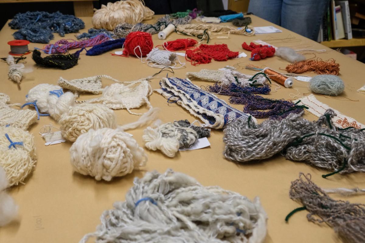 A table with a variety of different yarns varying in texture and size spread out.