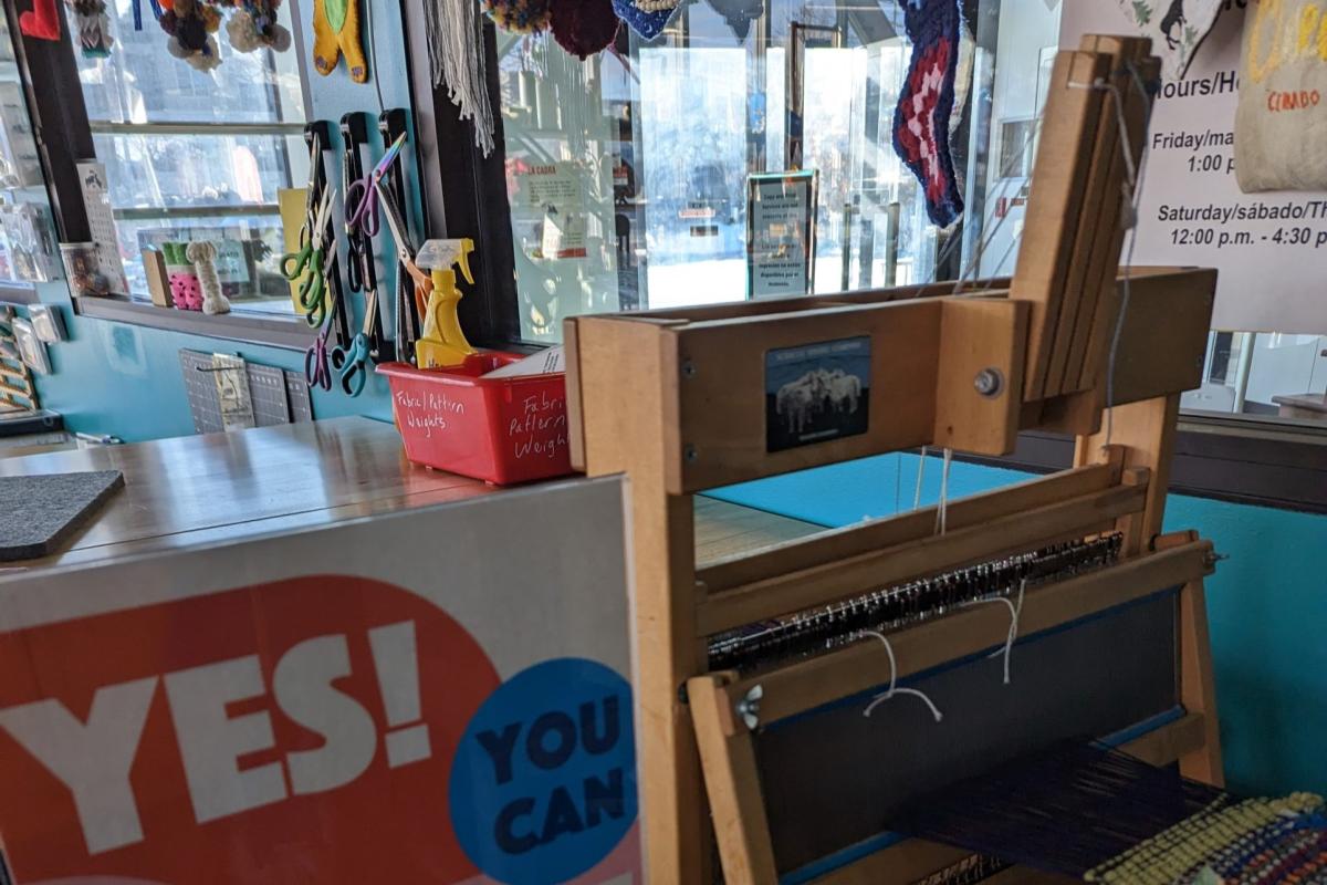 Loom in a room with balls of yarn and other craft implements