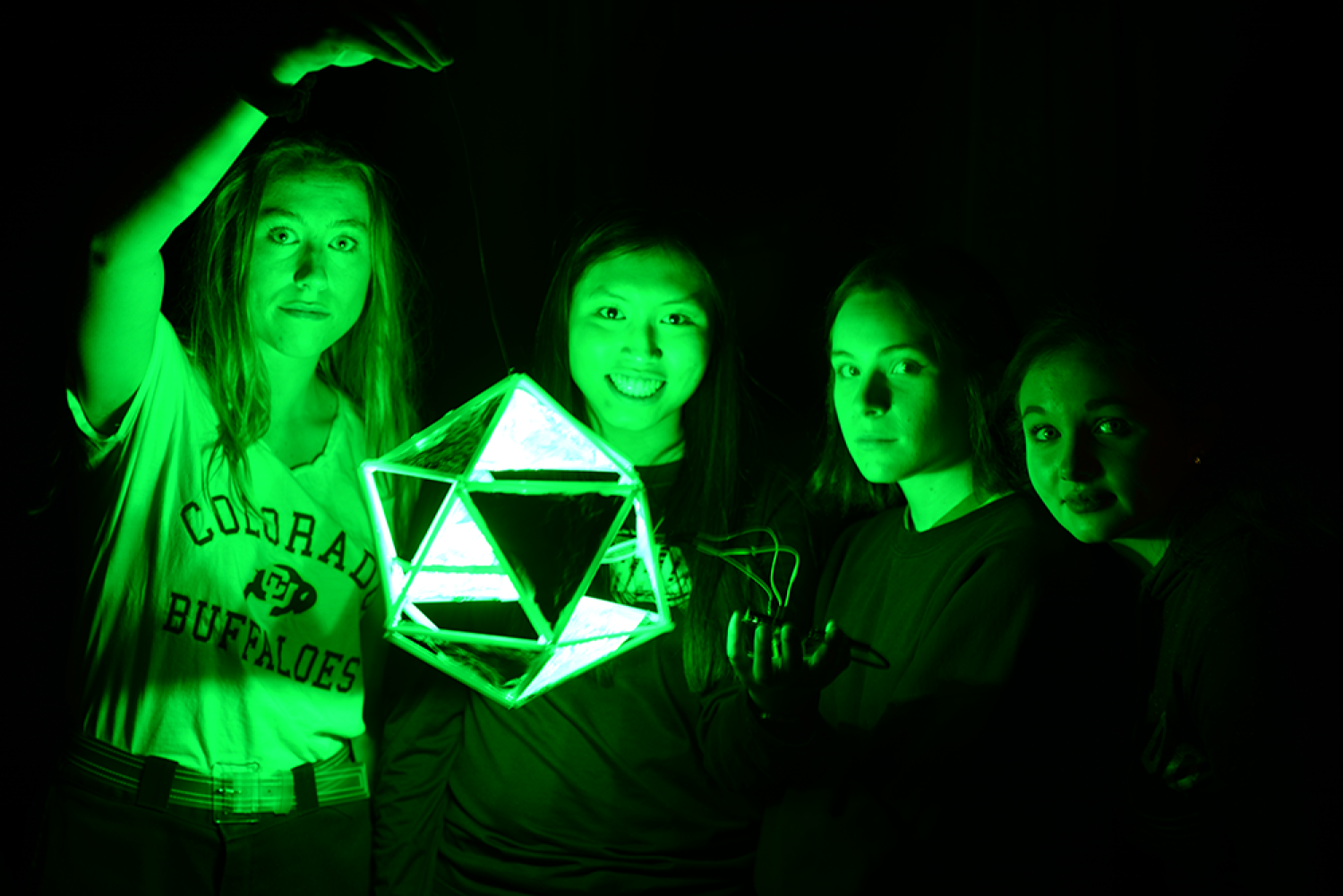 Students holding green lamp