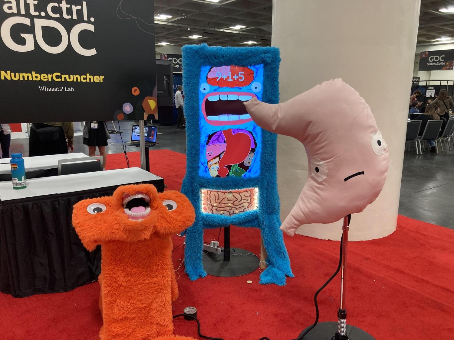 a furry screen, giant stuffed stomach, and an orange furry podium with teeth