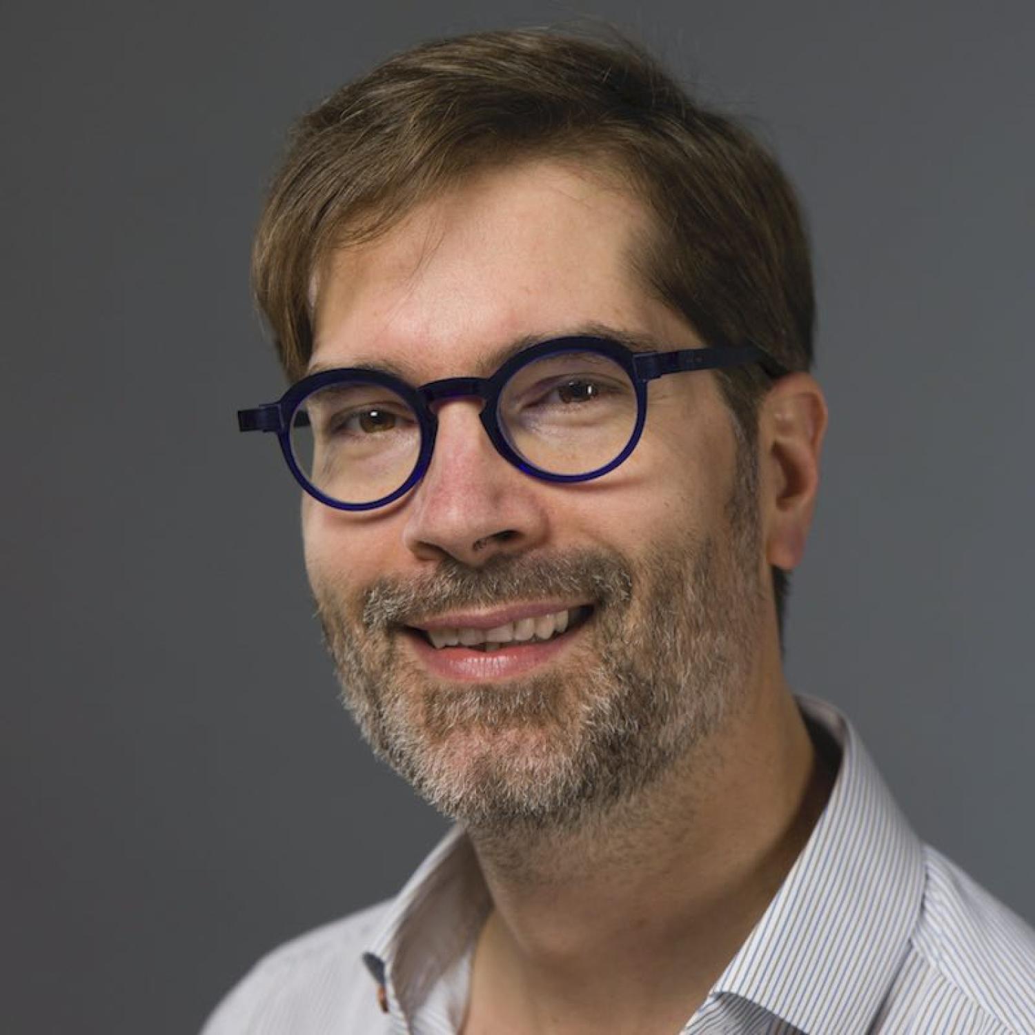 Profile of a middle-aged white man with short brown hair and beard, wearing glasses.