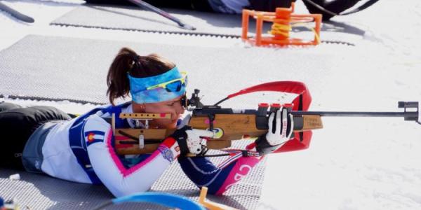 Joanne Reid pointing a rifle at her Biathlon target.