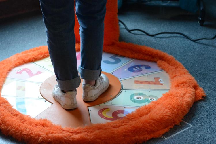 a person standing on an orange furry numbered foot controller