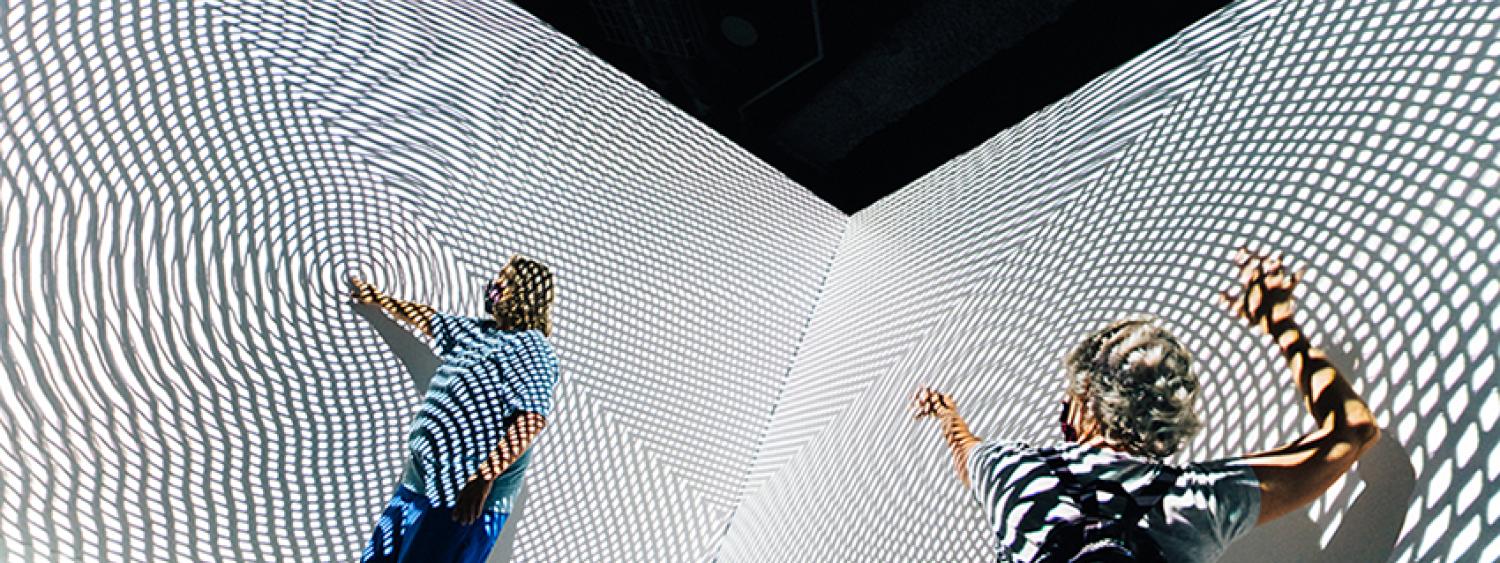 people dancing in front of black and white projection lines