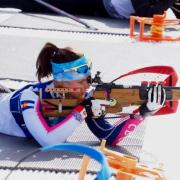 Joanne Reid pointing a rifle at her Biathlon target.