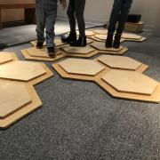 Legs of people standing on the musical hexagons.