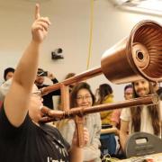 During the Moog Hackathon, Ruhan Wang demonstrates the e-trombone to the delight of other hackathon participants.