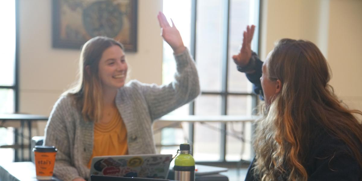 Two students high fiving