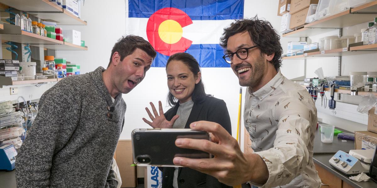 Three scientists standing in front of the Colorado flag