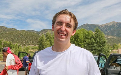 Connor Lacey at an outdoor event. The mountains are visible in the background.