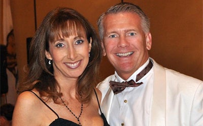 John Acker poses with his wife at a formal event