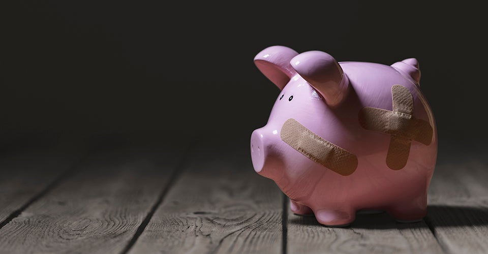 A piggy bank with bandages on it. 
