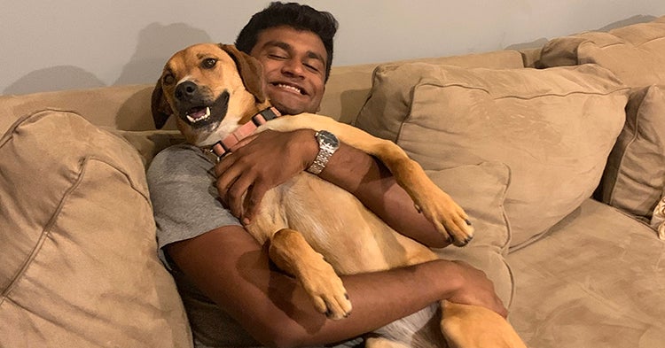 Atul holding his dog on a couch