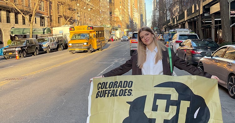 Lily Combs with a Buffs flag on the streets of Manhattan.
