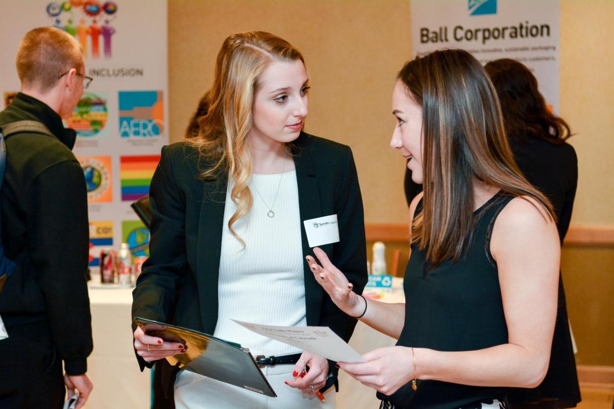 a business school student engaged with a corporate partner at a recruitment event