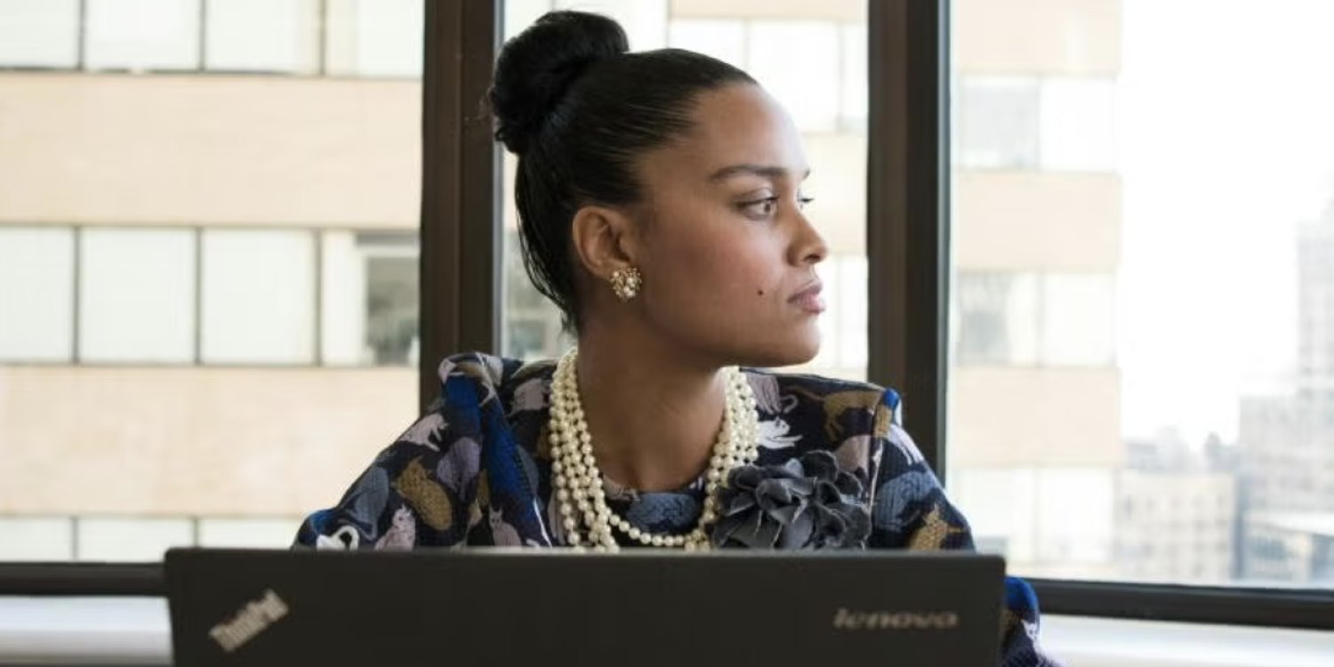 Woman working on a laptop looks off to the side