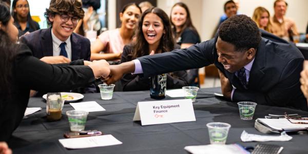Members of the winning Business Leadership Program team celebrate their victory by fist bumping.