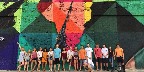 Global programs students standing in front of a painted mural in South Africa